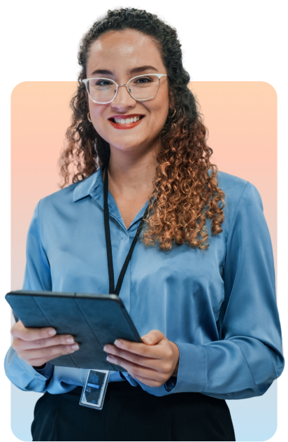 Uma jovem sorridente, de óculos e cabelo cacheado, usando uma blusa azul e um crachá. Ela está segurando um tablet.